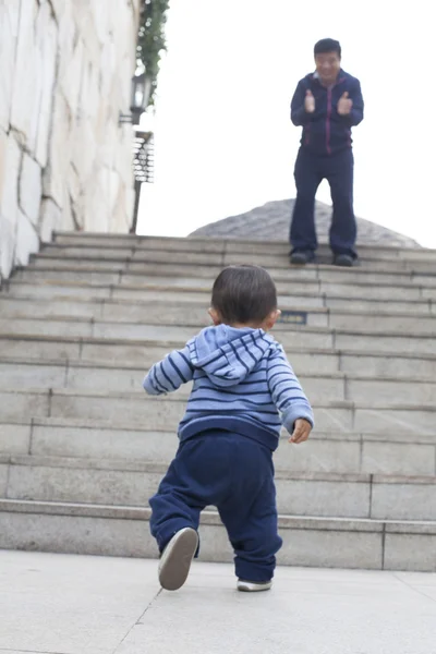 Cute Chinese baby boy learning walking, encouraged by his father — Stock Photo, Image