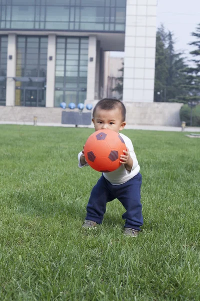 Şirin Çinli çayırda futbol oynarken bebeğim