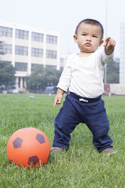 Şirin Çinli çayırda futbol oynarken bebeğim