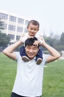 Mutlu Çin baba oğlu onun omuzlarında taşıyan