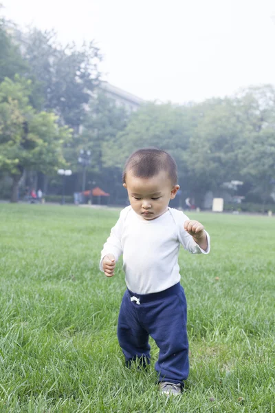 Lindo bebé chino corriendo en el prado — Foto de Stock