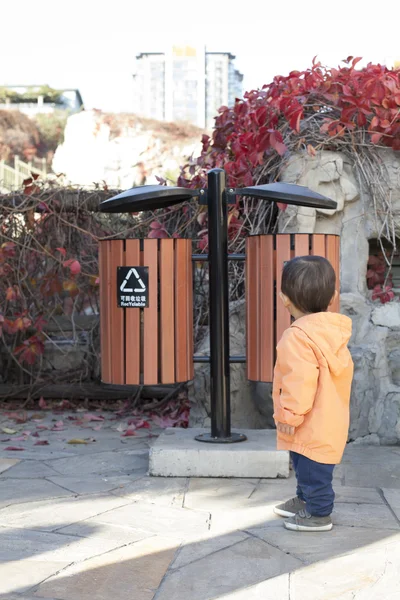 Chinese baby boy looking at a Garbage Bin — Stock Photo, Image