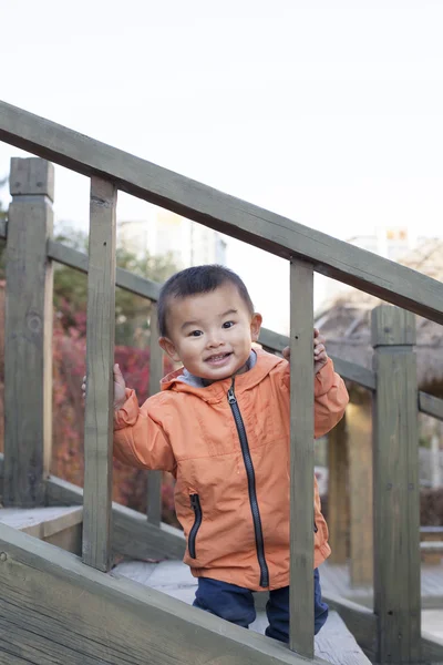 Счастливый китайский мальчик играет на лестнице под открытым небом — стоковое фото