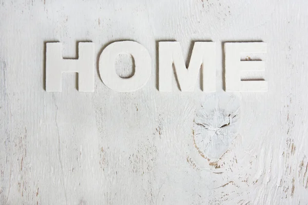 Het woord thuis gemaakt van houten letters op een witte achtergrond oude w — Stockfoto