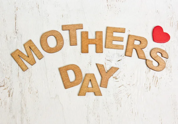 Dia das Mães com letras de madeira em um fundo branco velho — Fotografia de Stock