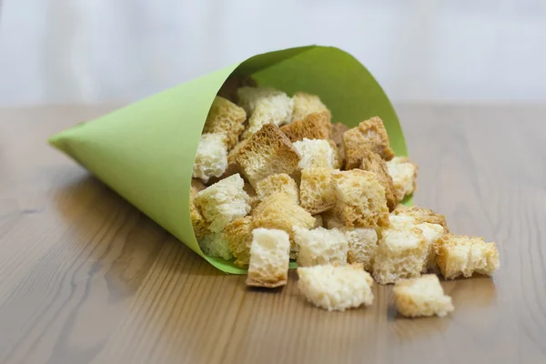 Croutons in green paper — Stock Photo, Image