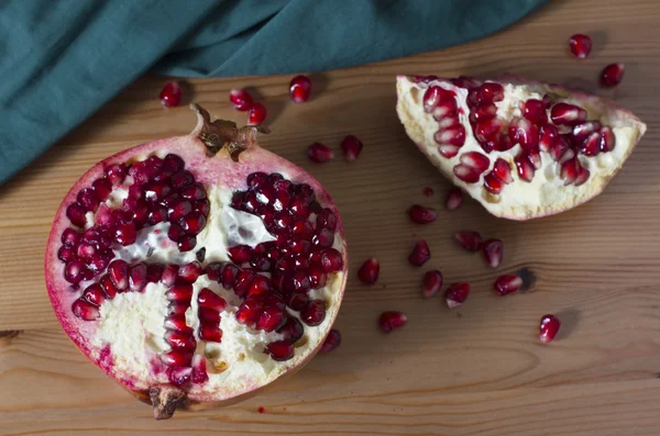 Bright red and juicy pomegranate on a table — Stock Photo, Image