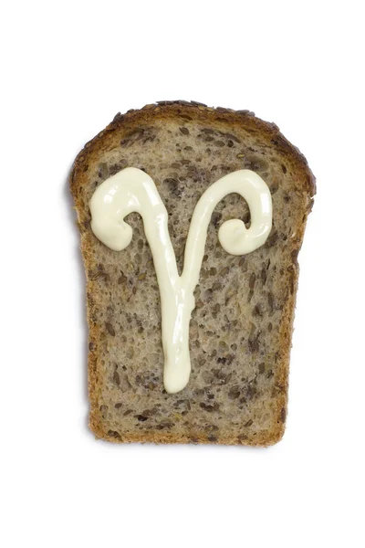 Symbole le aries est dessiné avec de la mayonnaise sur un morceau de pain Images De Stock Libres De Droits