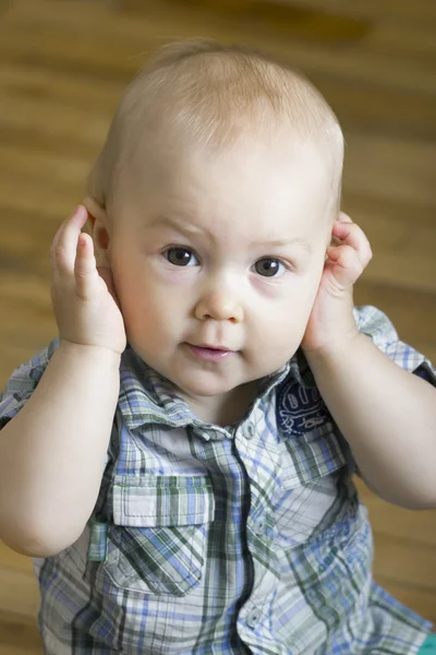 The boy raised a hands to his ears. Royalty Free Stock Images