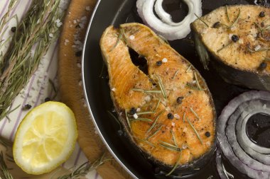 bir tava üzerinde çeşnilikler ile kızarmış balık