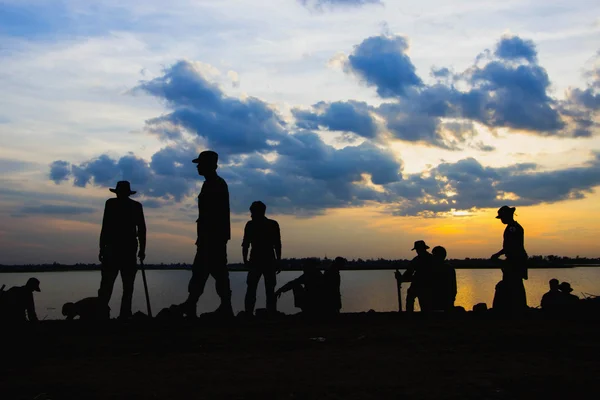 Soldaten rusten op de rivier bij zonsondergang. Rechtenvrije Stockfoto's