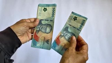 Endonezya rupia banknotlarını tutan ve sayan Asyalı kadınların yakın plan görüntüsü..