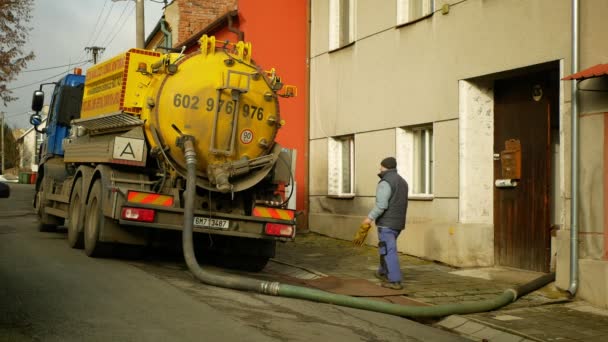 OLOMOUC, REPÚBLICA CHECA, JANEIRO, 20, 2021: Esvaziamento séptico Cesspool bombeamento em tubo tanque caminhão mangueira de sucção sob pressão. pessoas trabalhadores casas aldeia, sump contém poluição lodo esgoto água — Vídeo de Stock