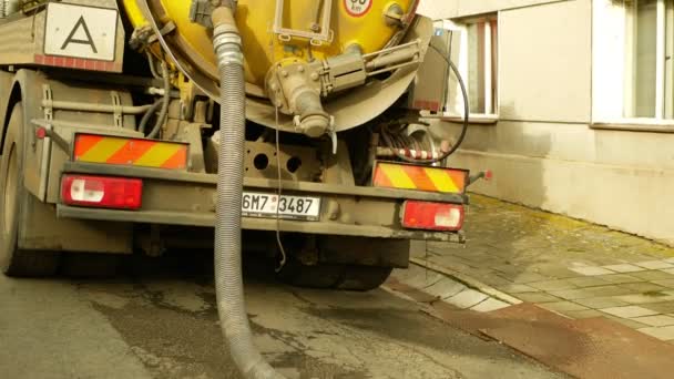 OLOMOUC, CZECH REPUBLIC, JANUARY, 20, 2021: Cesspool septic emptying pumping into pipe tank truck suction hose under pressure. people houses village, sump contains pollution sludge sewage water — Stock Video