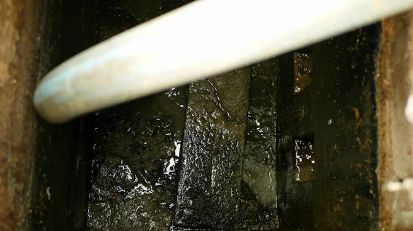 高圧下で吸引ホースによってパイプタンクにポンプを空にする敗血症の流出。このサンプには、汚染スラッジ下水黒い排水と糞、家庭からの排泄物が含まれています。 — ストック写真