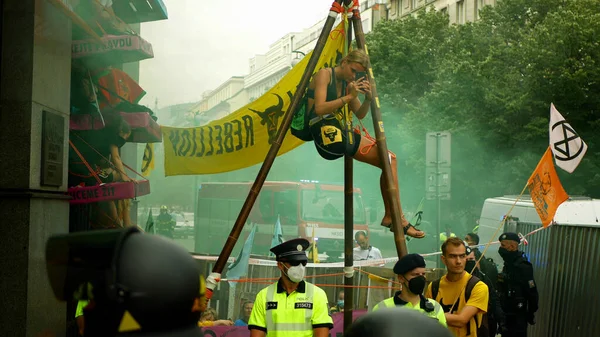 PRAAG, TSJECHIË, 28 juni 2021: Demonstratie Extinctie Opstand protestblokkade flara Bank, roken rookbom vrouw vastgebonden gebouw klimaatactivist oproerpolitie — Stockfoto