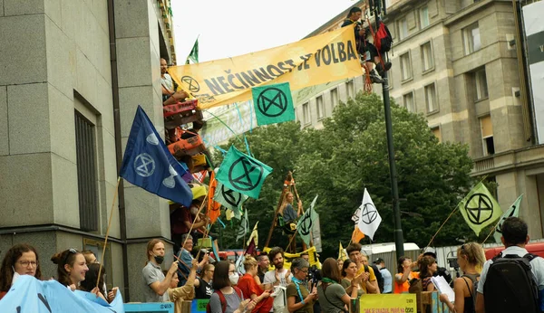 PRAAG, TSJECHIË, 28 juni 2021: Activisten activisme demonstratie Extinctie Opstand protestblokkade Bank, vlaggen symbool zandloper planeet waarschuwen mensen vastgebonden gebouw — Stockfoto