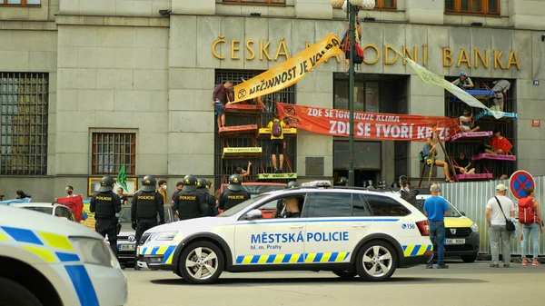 PRAGUE, REPÚBLICA CHECA, 28 DE JUNHO DE 2021: Manifestação Extinção Rebelião protesto bloqueio bloqueio bloqueio Banco, ativistas pessoas ativismo amarrado acorrentado edifício clima ativista, banner lâmpada de rua — Fotografia de Stock