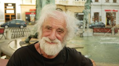 OLOMOUC, CZECH Cumhuriyet, 9 AĞUSTOS 2019: Dünyaca ünlü bir belgesel fotoğrafçısının Jindrich Streit portresi, Arion Fountain bir bankta oturuyor. Çek Üniversitesi öğretim üyesi, Avrupa