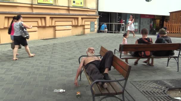 Brno, Tsjechië - 11 augustus 2015: authentieke emotie dakloze man in slaap op een bankje — Stockvideo