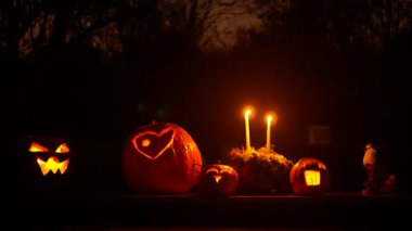 Cadılar Bayramı 'nda gülümseyen balkabağı mumları karanlık gecede yanıyor. Korkunç hasat zamanı. Jack o fener alevi parlayan canavar kutlaması. Hokkaido yığını, Cucurbita maxima pepo moschata yığını.