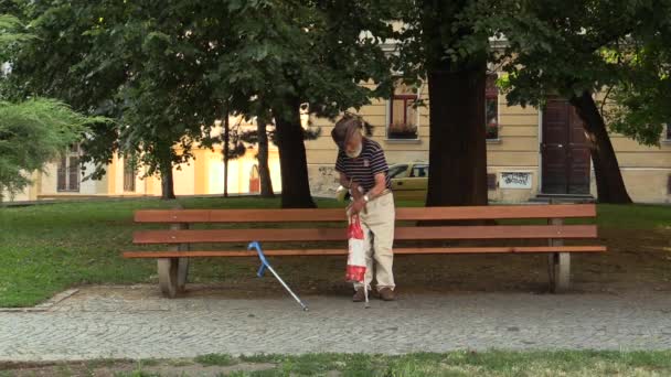 Olomouc, Çek Cumhuriyeti - 4 Temmuz 2015: koltuk değneği üzerinde park, South Moravia, Avrupa, AB bırakarak özürlü evsiz adam kıdemli — Stok video