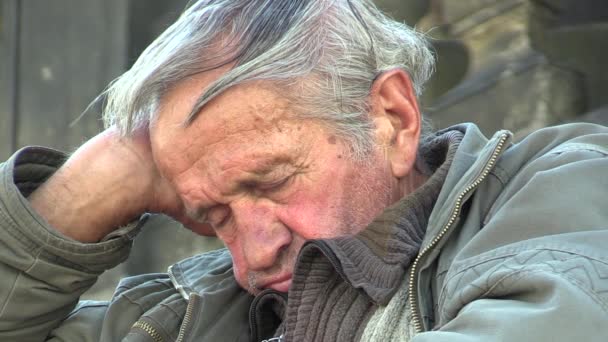 OLOMOUC, CZECH REPUBLIC - JULY 3, 2015: Authentic emotion homeless man senior asleep and awakening at the UNESCO heritage plague column, Central Moravia, Europe, EU — Stock Video