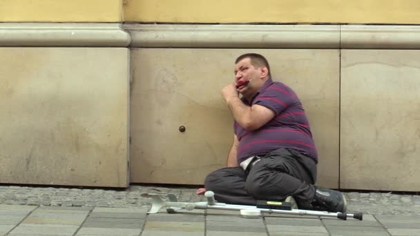 BRNO, REPÚBLICA CHECA - 27 DE AGOSTO DE 2015: Homem deficiente sênior em situação de rua na cidade implorando, toca harmónica e uma pessoa dá dinheiro, Morávia do Sul, Europa, UE — Vídeo de Stock