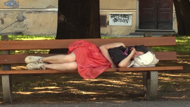 奥洛穆茨，捷克共和国-2015 年 7 月 4 日: 真实情感女孩在公园，南摩拉维亚地区，欧洲，欧盟的长凳上睡着了 — 图库视频影像