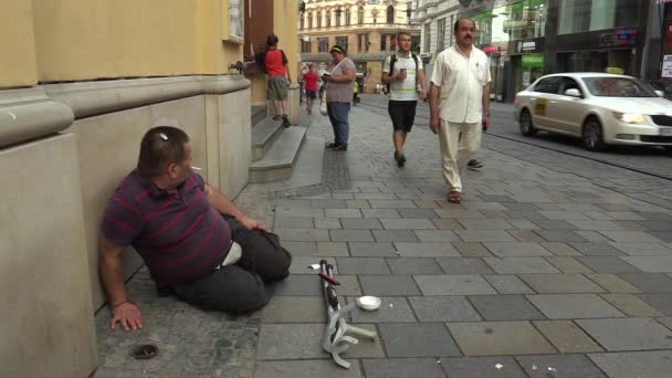 BRNO, REPÚBLICA CHECA - 27 DE AGOSTO DE 2015: Hombre discapacitado mayor, falso sin hogar en la ciudad mendigando, fumando un cigarrillo y una llamada telefónica, Moravia del Sur, Europa, UE — Vídeos de Stock