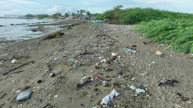 Plastik çöplerle dolu kıyı şeridi çöplüğü ve ezici miktarda çöp. Çevre kirliliği ve okyanus kirliliği. Deniz kıyısındaki döküntüler cam gibi, metal plaja gidenler için tehlikeli olabilir. Denizciyi, denizi kirletti ve kötüye kullandı.