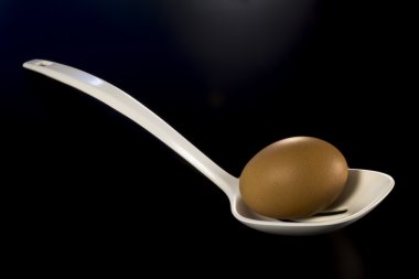 Siyah bir zemin üzerine plastik kaşıkla yumurta