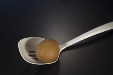Siyah bir zemin üzerine plastik kaşıkla yumurta