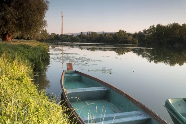     Güneşin doğuşunda bir gölde tekne 
