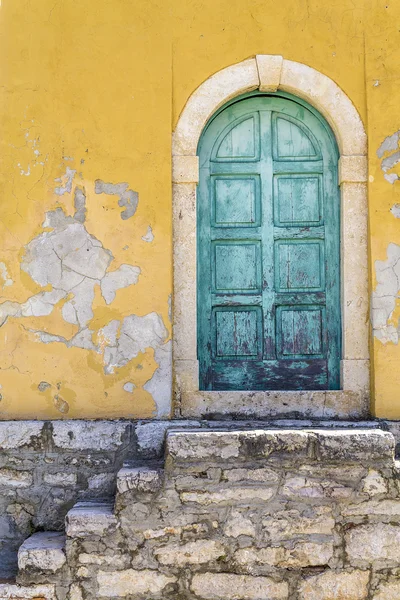 Antigua puerta verde rústica en una pared amarilla — Foto de Stock