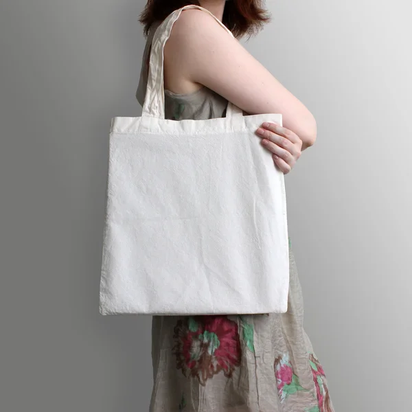 Girl is holding blank cotton eco tote bag, design mockup.