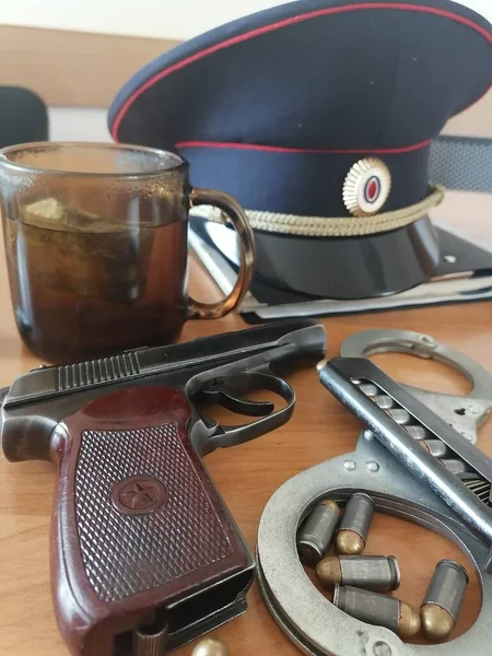 gun handcuffs and a cap are on the table