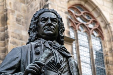 Leipzig 'deki Thomaskirche' in önündeki besteci Johann Sebastian Bach 'ın anıtı. Leipzig şehir merkezindeki ünlü barok bestecisinin tarihi anıtına yakın plan, arka plan St. Thomas Kilisesi..