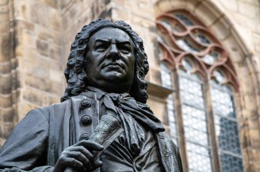 Monument to the composer Johann Sebastian Bach in front of the Thomaskirche in Leipzig. Close-up of the historical monument of the famous baroque composer in the city center of Leipzig, in the background the St. Thomas Church.