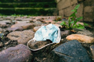 Salgının sonucu olarak kirlilik: kaldırıma atılan cerrahi yüz maskesi