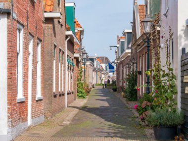 WOUDSEND, NETHERLANDS - OCT 1, 2017: Street scene of narrow Midstrjitte street in village of Waldsein, Woudsend, Friesland