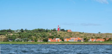 West Frisian island Vlieland with Vuurduin lighthouse on vuurboetsduin and East-Vlieland town from Wadden Sea, Friesland, Netherlands clipart
