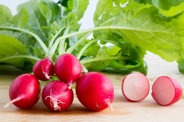 Fresh radishes, Raphanus sativus, on wooden plate — Stock Photo, Image