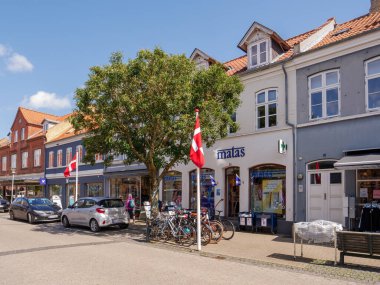 Kerteminde, Danimarka - 5 Ağustos 2025 Langegade, merkez kasaba Funen, Güney Danimarka boyunca bisikletli ve Danimarka bayraklı Matas mağazası