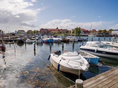 Kerteminde, Danimarka - 5 Ağustos 2025: Kerteminde limanında demirlemiş küçük motorlu tekneler ve arka planda tarihi liman binaları, Funen, Güney Danimarka