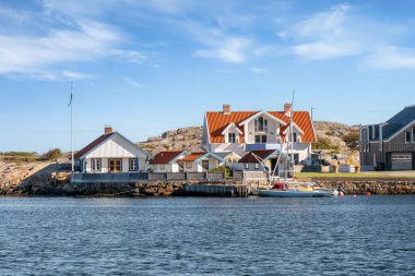 Marstrand, İsveç - 16 Ağustos 2025: Liman kıyısı kıyı binaları, su üzerinden görünen tekneler, Koon, Bohuslan, batı kıyısı İsveç
