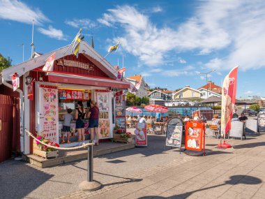 Lysekil, İsveç - 17 Ağustos 2025: Lysekil, Bohuslan, İsveç 'in batı kıyısındaki Strandpromenaden' de açık hava ve yiyecek tezgahlı dondurma büfesi, güneşli yaz günü dondurma sipariş eden insanlar