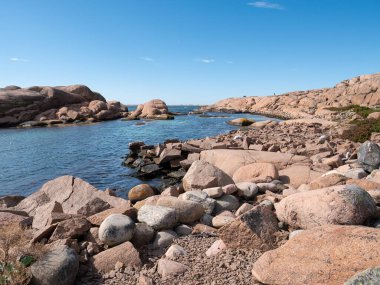 İsveç 'in batısındaki Lysekil, Bohuslan yakınlarındaki Staangehuvud doğa koruma alanında dağılmış kaya parçaları ve pürüzsüz kaya oluşumlarıyla Granit kayalık kıyı şeridi.