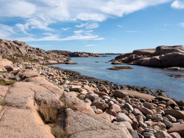 İsveç 'in batısındaki Lysekil, Bohuslan yakınlarındaki Staangehuvud doğa koruma alanında dağılmış kaya parçaları ve pürüzsüz kaya oluşumlarıyla Granit kayalık kıyı şeridi.