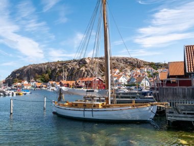 Fjallbacka, İsveç - 19 Ağustos 2025: Tarihi eski kasaba ve Fjallbacka, Bohuslan, batı kıyısı İsveç 'te Vetteberget limanında demirlemiş yelkenli